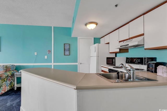 kitchen featuring light countertops, white cabinets, under cabinet range hood, and a peninsula