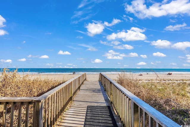 view of community featuring a beach view and a water view