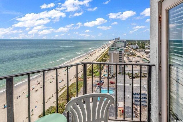 balcony featuring a water view, a swimming pool, and a view of the beach