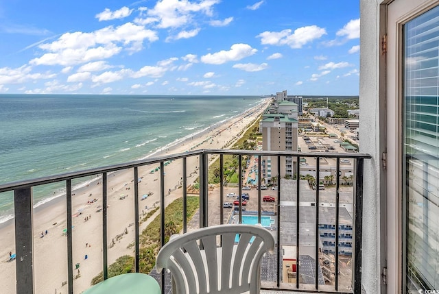 balcony with a water view and a view of the beach