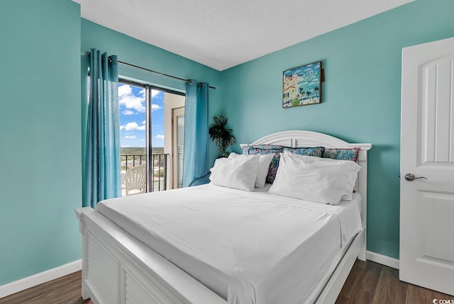 bedroom with dark hardwood / wood-style flooring, a textured ceiling, and access to outside