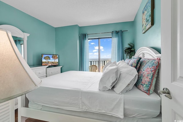 bedroom featuring access to exterior and a textured ceiling