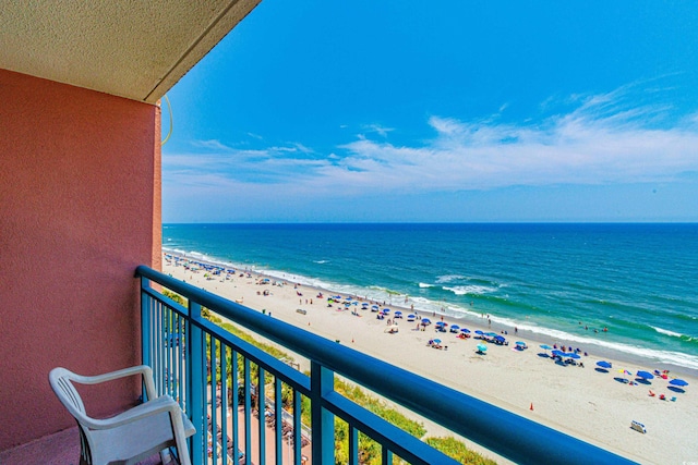 balcony featuring a view of the beach and a water view