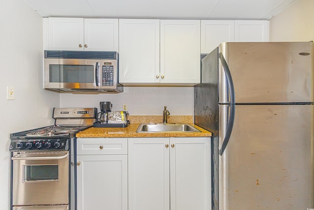 kitchen featuring stainless steel appliances, sink, and white cabinets