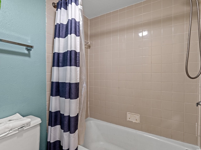 bathroom with shower / bath combination with curtain and toilet