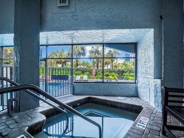 view of swimming pool with an indoor hot tub