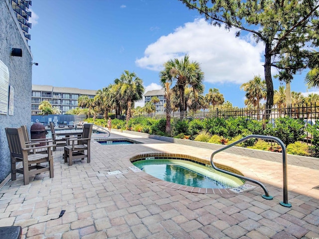 view of pool featuring a patio and a hot tub