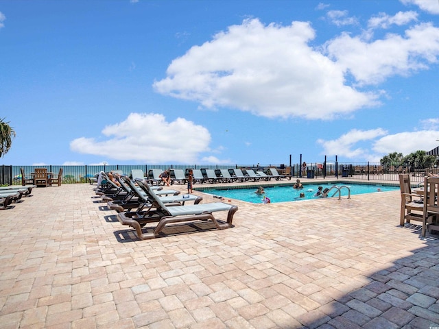 view of swimming pool with a patio and a water view