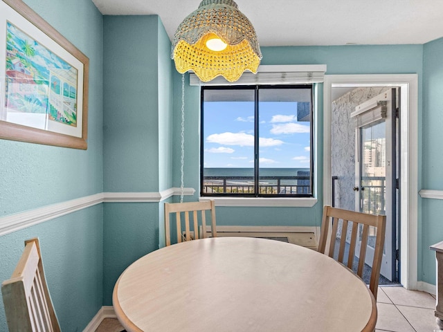 tiled dining space featuring radiator and a water view