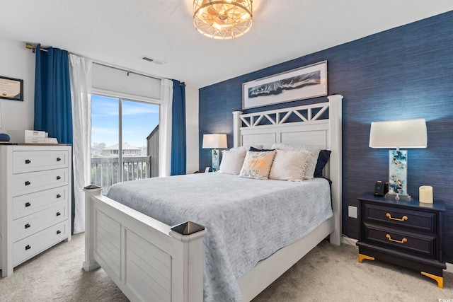 bedroom with access to outside and light colored carpet