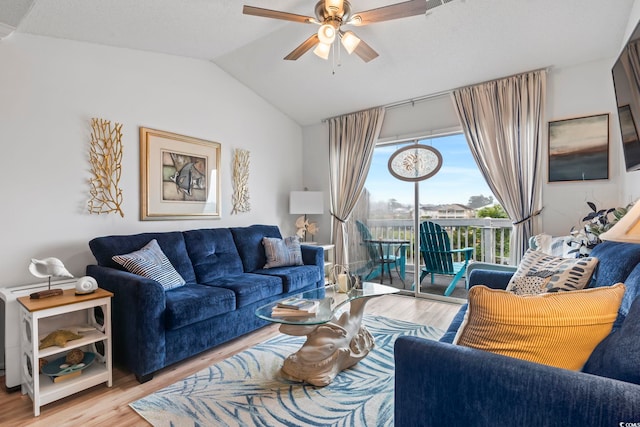 living room featuring ceiling fan, vaulted ceiling, and light hardwood / wood-style floors