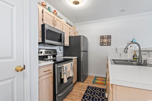 kitchen featuring appliances with stainless steel finishes, lofted ceiling, sink, and light hardwood / wood-style flooring