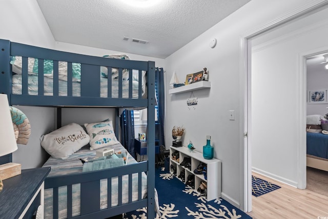 bedroom with wood-type flooring and a textured ceiling