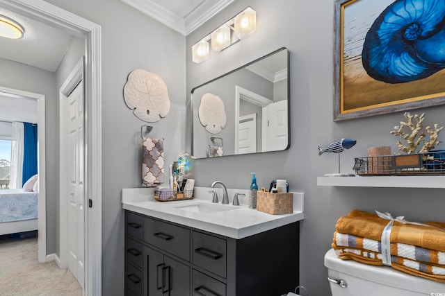 bathroom with vanity, crown molding, and toilet