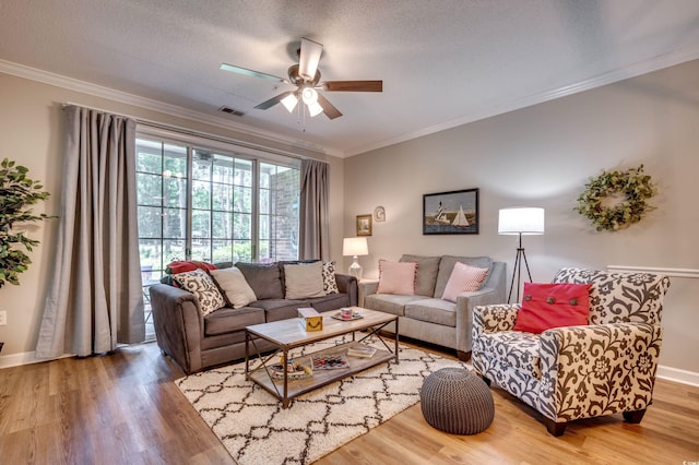 living room featuring hardwood / wood-style floors, ornamental molding, a textured ceiling, and ceiling fan