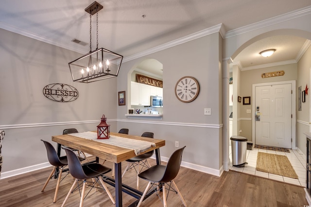 dining area with crown molding and hardwood / wood-style floors