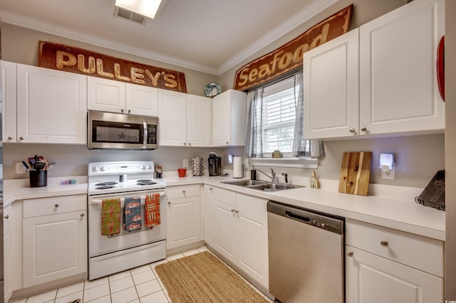 kitchen with sink, white cabinetry, crown molding, light tile patterned floors, and appliances with stainless steel finishes