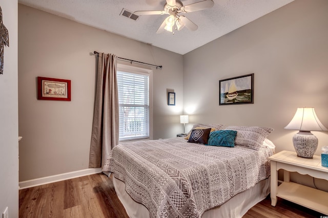 bedroom featuring hardwood / wood-style flooring, a textured ceiling, and ceiling fan