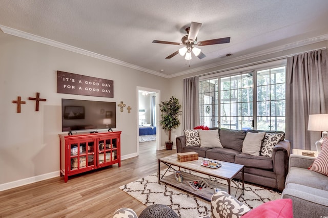 living room featuring ceiling fan, hardwood / wood-style flooring, ornamental molding, and a textured ceiling