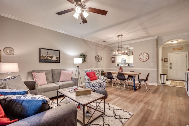 living room featuring hardwood / wood-style floors, ornamental molding, and ceiling fan