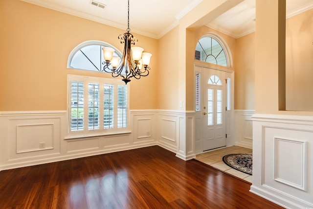 foyer featuring a chandelier, hardwood / wood-style flooring, and ornamental molding