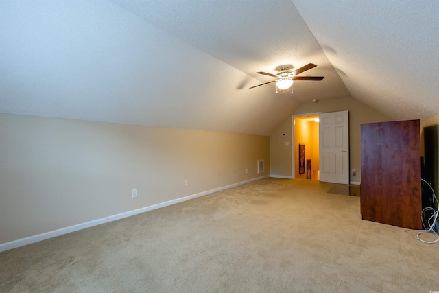 additional living space featuring light colored carpet, ceiling fan, and lofted ceiling