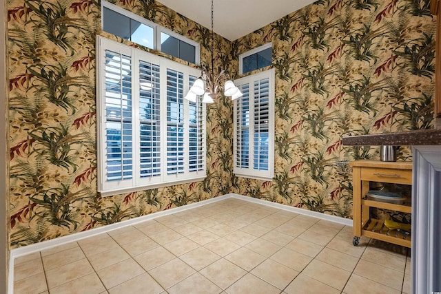 unfurnished room featuring tile patterned flooring, a wealth of natural light, and a notable chandelier