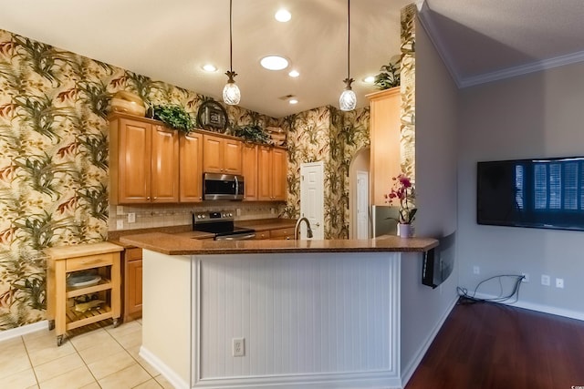 kitchen featuring pendant lighting, kitchen peninsula, ornamental molding, and appliances with stainless steel finishes