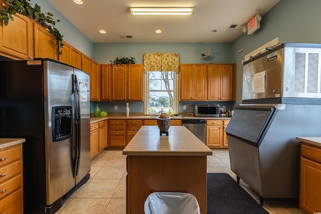 kitchen with a kitchen island, sink, light tile patterned floors, and stainless steel appliances