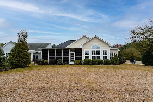 rear view of house with a yard and a sunroom