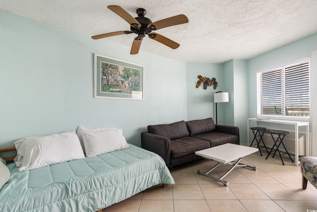 living room featuring tile patterned floors, a ceiling fan, and a textured ceiling