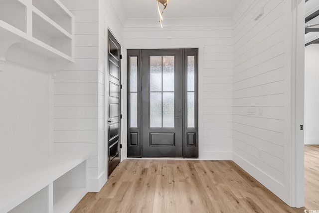 mudroom featuring wood walls and light wood-type flooring