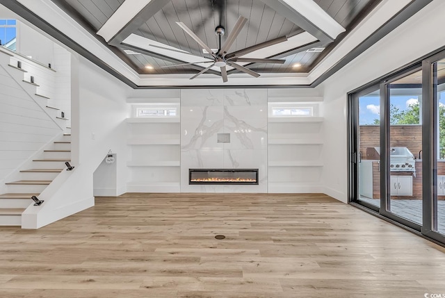 unfurnished living room with light hardwood / wood-style flooring, crown molding, a fireplace, and ceiling fan