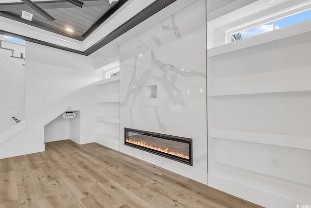 detailed view of a large fireplace, built in features, wood finished floors, recessed lighting, and baseboards
