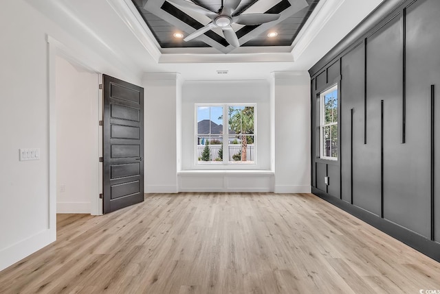 unfurnished bedroom featuring light wood-style floors, ornamental molding, a tray ceiling, baseboards, and recessed lighting