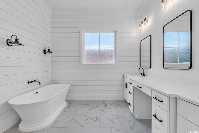 bathroom featuring vanity, a healthy amount of sunlight, wooden walls, and a bathtub