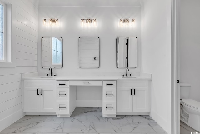 bathroom with toilet, vanity, and a wealth of natural light