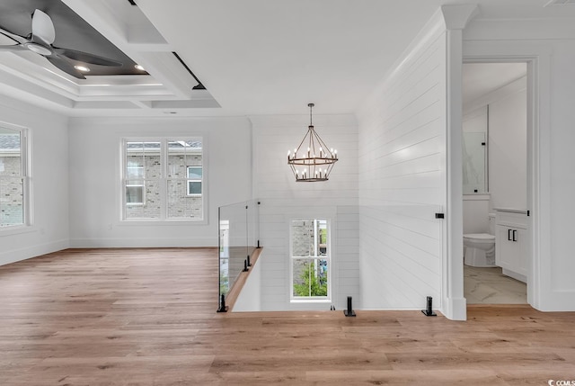 entrance foyer featuring light hardwood / wood-style flooring, ornamental molding, a tray ceiling, and ceiling fan with notable chandelier