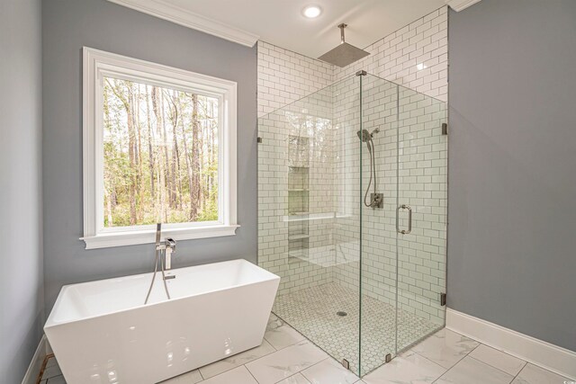 bathroom with ornamental molding, separate shower and tub, and a wealth of natural light