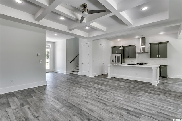 unfurnished living room featuring coffered ceiling, beam ceiling, hardwood / wood-style flooring, and ceiling fan