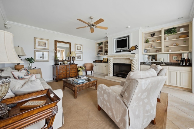 living area featuring built in shelves, crown molding, light tile patterned floors, a high end fireplace, and ceiling fan