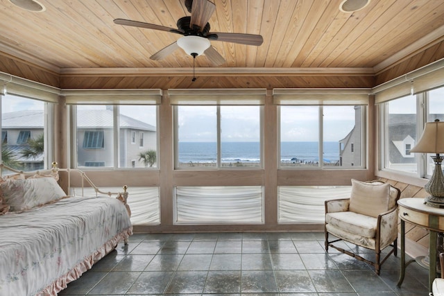 interior space with a water view, wood ceiling, and a ceiling fan