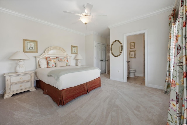 bedroom with crown molding, a closet, light colored carpet, ensuite bath, and baseboards