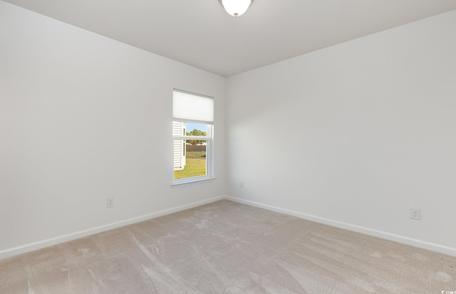 spare room featuring light carpet