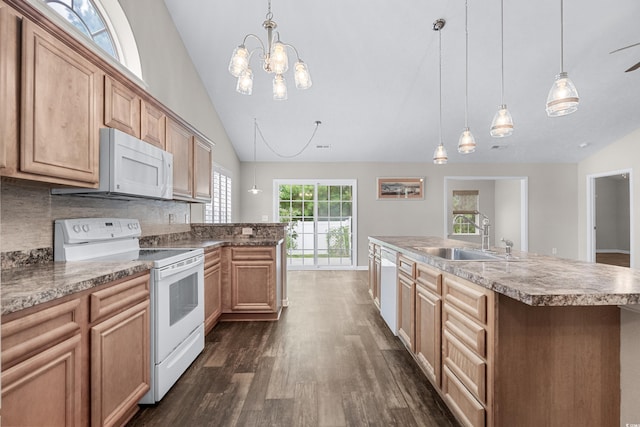 kitchen with white appliances, a kitchen island with sink, sink, decorative backsplash, and decorative light fixtures