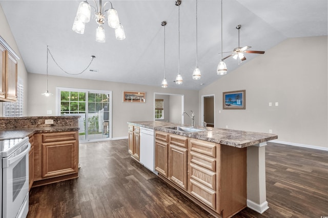 kitchen with white appliances, a kitchen island with sink, sink, pendant lighting, and dark hardwood / wood-style floors