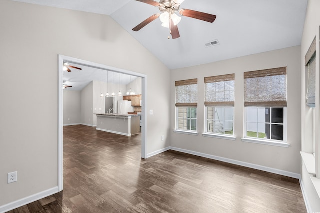 spare room featuring dark hardwood / wood-style flooring and lofted ceiling