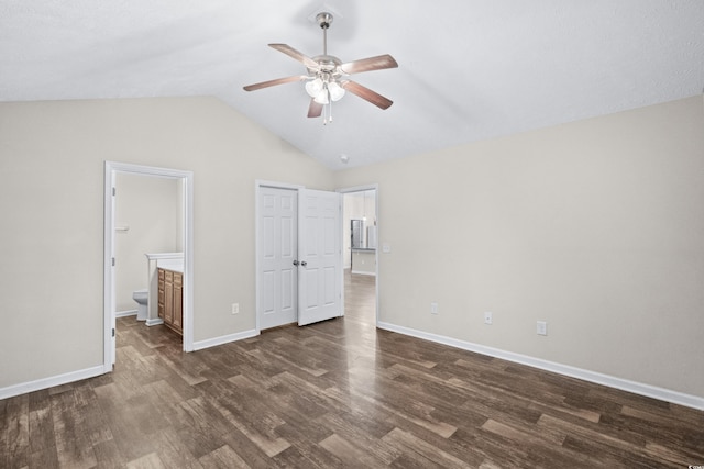 unfurnished bedroom featuring ceiling fan, dark hardwood / wood-style flooring, ensuite bathroom, and vaulted ceiling