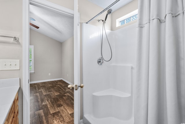 bathroom with a shower with shower curtain, vanity, hardwood / wood-style flooring, and vaulted ceiling