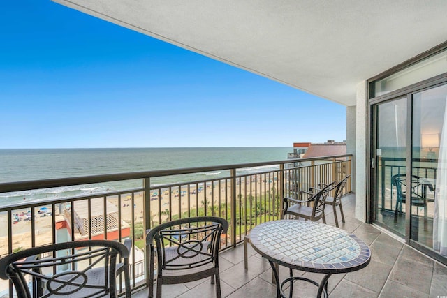 balcony featuring a beach view and a water view